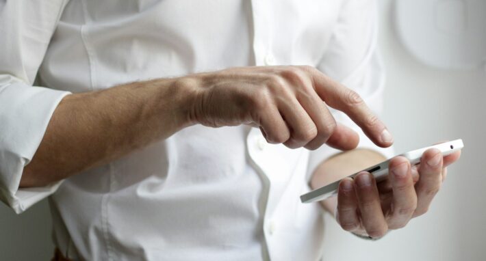 person holding white Android smartphone in white shirt